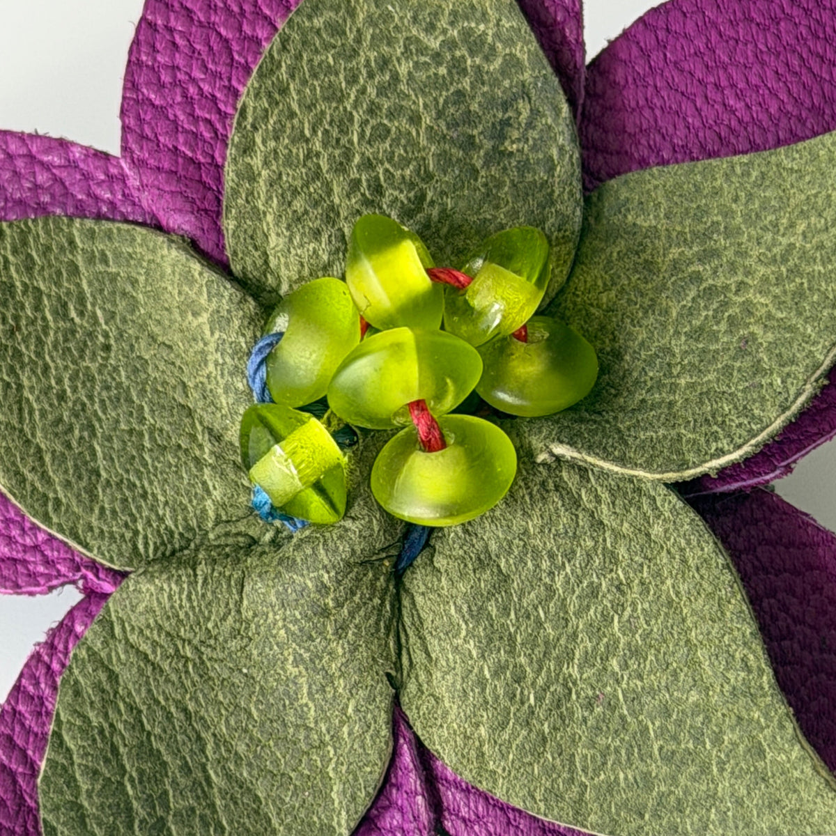 The Estrella- close-up of a flower-shaped hair clip with leather -kidskin purple petal