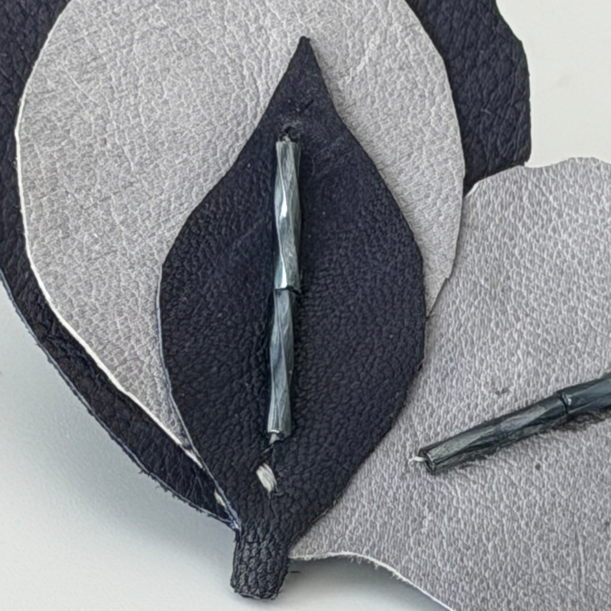  close-up of a handmade leaf-shaped leather accessory