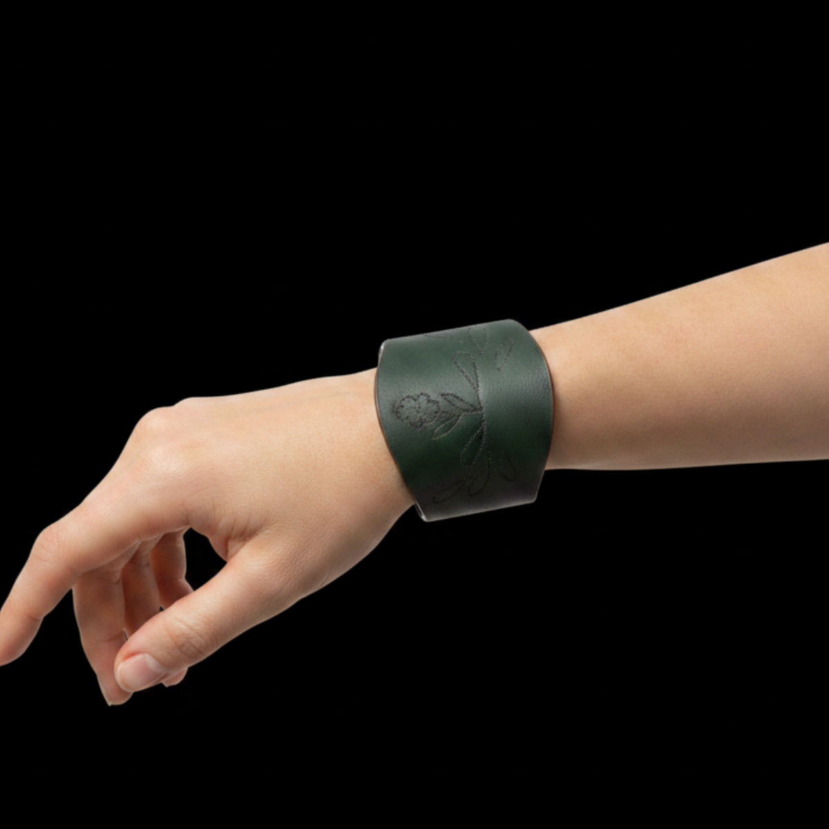 Forest green leather cuff on model hand black background