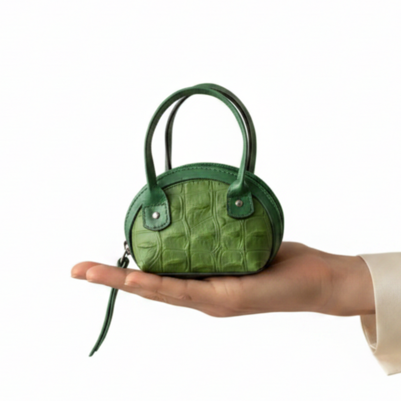 Hand only holding green mini bag